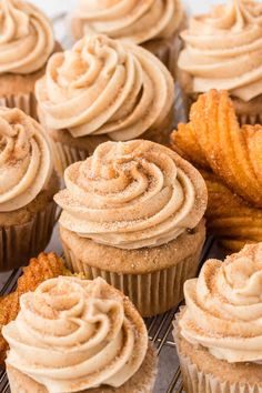 cupcakes with frosting and cinnamon chips on a cooling rack