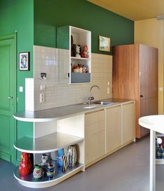 a kitchen with green walls and white counters