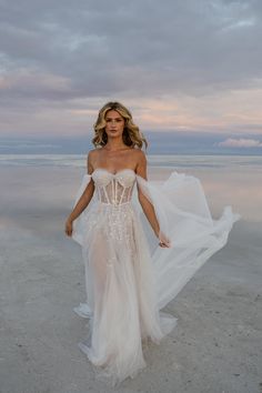 a woman in a white dress on the beach