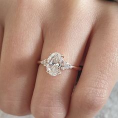 a woman's hand with a diamond ring on top of her finger and two diamonds in the middle