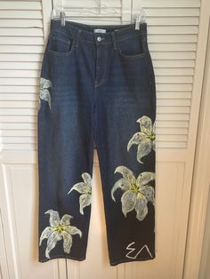 Listing for completely hand-painted custom flower jeans. These flowers were painted on Forever 21 waist 28 in women's straight leg "90s fit" dark wash jeans from their "premium" line, and the high quality acrylics have been heat sealed with an iron. Please hand wash as the paint is water proof but machine washing risks the colors dulling.  The price given includes shipping.  You are purchasing wearable art, please see bottom of description as I do not accept returns or refunds.  Please note that there are some flaws on the flaws which include but are not limited to: small cracks, discoloration, human error in painting, small smudges, etc.  The logo seen at the bottom of the leg on the front, the E with upside down V is my old shops logo, and these are simply relisted here on Etsy.  IMPORTA Hand Painted Straight Leg Jeans For Spring, Hand Painted Blue Jeans For Spring, Painted Jeans Flowers, Hand Painted Straight Leg Cotton Jeans, Hand Painted Flower Jeans, Flower Jeans, 90s Fits, Embellished Jeans, Dark Wash Jeans