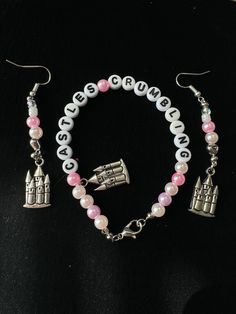 a bracelet and earrings with charms are on a black surface, one is made out of beads