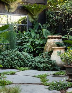 an outdoor garden with potted plants and mirrors