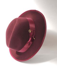 A timeless chic Trilby featuring a tonal satin hat band and inner petersham ribbon. Handcrafted in wool felt with a wired brim for fashioning to suit. Maximum size 57cm. Inside adjuster for one size fits all. Formal Solid Fedora With Flat Crown, Elegant Panama Hat With Flat Crown For Fall, Wool Fedora With Curved Brim, Wool Fedora With Curved Brim In Solid Color, Solid Wool Fedora With Curved Brim, Elegant Solid Fedora With Curved Brim, Elegant Wool Fedora For Winter, Fitted Panama Hat With Flat Crown For Formal Occasions, Solid Wool Fedora With Wide Brim