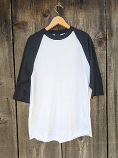 Classic Y2K raglan tee, early 2000s vintage. A flattering and comfy oversize t shirt, in a cool black & white two-tone. Great as retro athletic wear, or everyday casual. Brand : EASTON 60% cotton, 40% polyester Labeled size L I'd say fits like a Men's L, Ladies' XL All measurements taken with garment lying flat, double where necessary roughly 17 inches shoulder to shoulder 21 inches pit to pit 21 inches across hem 28 inches from neckline to hem 15 inch sleeve length Very good vintage condition. Cotton Tops With Contrast Sleeves For Streetwear, Cotton Top With Contrast Sleeves For Streetwear, White Sporty T-shirt With Contrast Sleeves, Sporty White T-shirt With Contrast Sleeves, White Cotton Tops With Baseball Collar, White Cotton Baseball Jersey With Crew Neck, White Cotton Baseball Jersey For Baseball Season, White Cotton Baseball Jersey, White Cotton Sporty Baseball Jersey