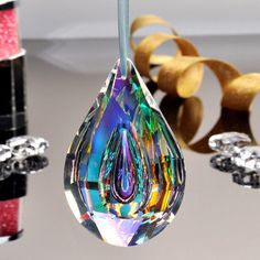 a drop shaped glass ornament hanging from a string