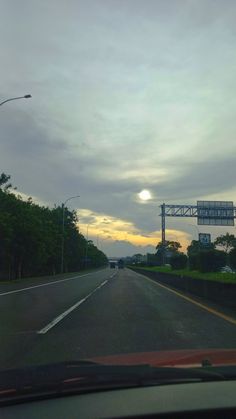 the sun is setting on an empty highway