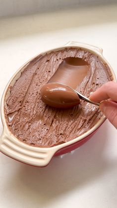 a person is spooning chocolate into a dish