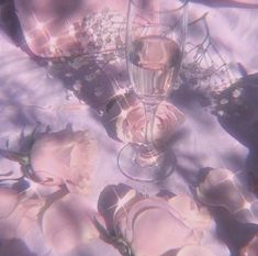 a table topped with pink flowers and wine glasses