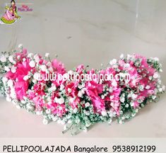 pink and white flowers are arranged in the shape of a flower arrangement with baby's breath