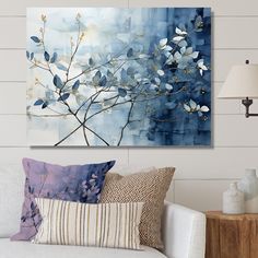 a living room scene with focus on the couch and wall art that has blue flowers