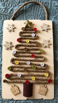 a christmas tree made out of cardboard with buttons on the bottom and a string attached to it