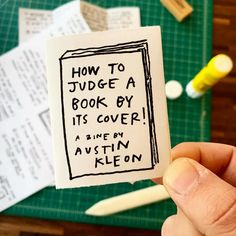 someone is holding up a piece of paper that says how to judge a book by its cover