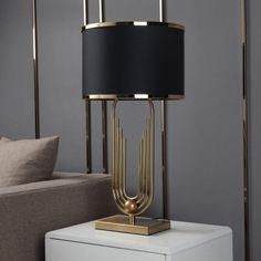 a table lamp sitting on top of a white cabinet next to a couch in a living room