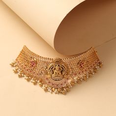 Description Feel the royal elegance of this antique choker necklace, designed with exquisite details that will make you stand out - The graceful Goddess Lakshmi sits on a lotus flower, surrounded by beautiful peacock & mango patterns, all adorned with beads and a pearl drop. This is the perfect accessory for your special occasion. Details & Specifications: Materials used: Brass Alloy with Antique Gold Plating Weight – Choker 63.97 gm, Earrings 33 gm Length – Choker 15 cm, Earrings 4.5 cm Make it Choker Designs, Goddess Lakshmi, Pearl Drop, Antique Gold, Special Occasion, Choker Necklace, Beautiful Jewelry, Jewelry Box, Gold Plate