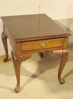 a small wooden table with two drawers on it