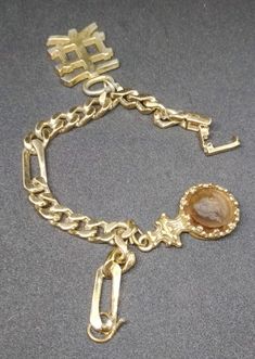 "Welcome! Vintage Designer Pierre Cardin Bracelet Gold tone chain with charms- brand is in closer of bracelet. In good vintage condition. One charm lost a bit gold tone (attention pics). Another charm is like a face glass really nice. Measures: 7.48\" (19 cm) Perfect for your vintage look! Thanks for stopping by!!IMPORTANT: Due to the delicate situation We're all going through, and in order to keep the safety of courier workers too, all orders will be dispatched when alert sanitary finished. You Vintage Gold Collectible Bracelets, Vintage Gold Bracelets As Collectibles, Vintage Gold Bracelets For Collectors, Antique Gold Bracelet With Lobster Clasp, Gold Engraved Metal Charm Bracelet, Engraved Gold Metal Charm Bracelet, Vintage Gold-tone Chain Bracelet, Vintage Gold Metal Chain Bracelet, Vintage Gold Bracelet With Charms