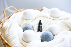 a basket filled with pom poms on top of a wooden table next to a bottle