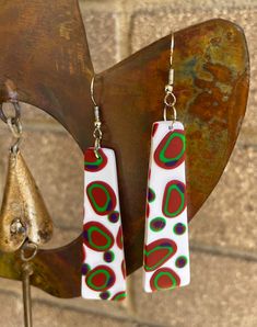 These fun boho style earrings come in 2 sizes. Each pair has different coloured dots randomly arranged on the earring. They have a slight texture to them. They are bright and fun. All of my earrings are handmade using Polymer Clay which keeps them very light to wear. No 2 pairs are ever the same and as they are hand made they may have very slight imperfections but that is the beauty of handmade. I take care to represent the true colour of the earrings. I hope you love wearing the earrings as much as I loved making them. Retro White Dangle Earrings, Handmade Funky Dangle Earrings, Retro White Drop Earrings, Retro White Earrings For Gift, Handmade White Artsy Earrings, Fun Nickel-free White Earrings, Fun White Nickel-free Earrings, Playful White Nickel-free Earrings, Playful White Earrings With Ear Wire