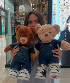 a woman holding two teddy bears in her arms