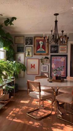 a dining room table with chairs and pictures on the wall in front of it's windows