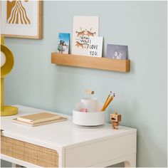 a desk with some items on it and a shelf above the desk that says i love you