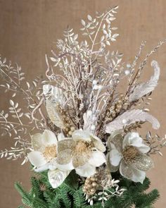 a vase filled with white flowers and greenery