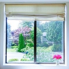 a vase with pink flowers sitting on top of a window sill