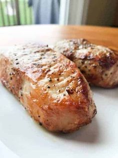 two pieces of meat sitting on top of a white plate