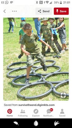 an image of a boy playing with water hoses on the grass in front of other children