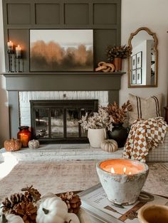 a living room filled with furniture and a fire place in front of a fireplace covered in candles