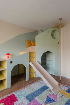 a child's bedroom with bunk beds and play equipment in the corner, including a slide