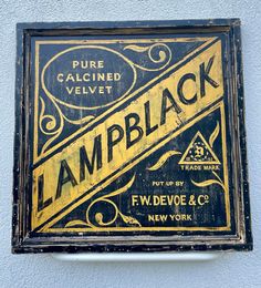 an old black and yellow sign on the side of a building that says lampblack