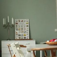 a dining room table with chairs and a basket on top of it next to a white dresser