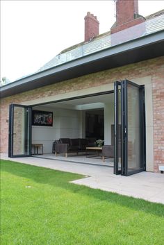 an open patio area with sliding glass doors on the outside and brick building in the background