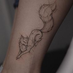 a black and white photo of a small fox tattoo on the ankle, with lines running through it