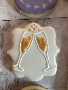 two decorated cookies with champagne glasses on them