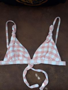 This is such a darling bikini top with a country girl look to it. The straps are adjustable and the little bows at the top or just darling. The back ties and there's an area inside the bikini top for putting pads. It is a size 3-5 or small. The coloring is more of a deep and light peach and cream or off-white.  The fabric is like a stretch waffle weave and quite soft. Pink Tie-strap Swimwear For The Beach, Vacation Gingham Swimwear With Adjustable Straps, Poolside Gingham Swimwear With Adjustable Straps, Gingham Swimwear With Adjustable Straps For Poolside, Summer Swimwear With Adjustable Strap For Poolside, Adjustable Strap Swimwear For Summer Beach, Adjustable Tie Strap Swimwear For Summer, Adjustable Strap Swimwear For Poolside In Summer, Beachwear Swimwear With Adjustable Tie Straps