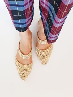 a woman's legs wearing plaid pants and sandals