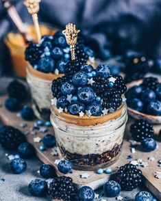 two jars filled with blueberries and oatmeal sitting on top of a table