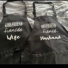 two black aprons with white writing on them that say girlfriend, boyfriend and husband