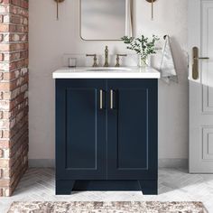 a bathroom with a brick wall and blue cabinetry, white countertop and mirror