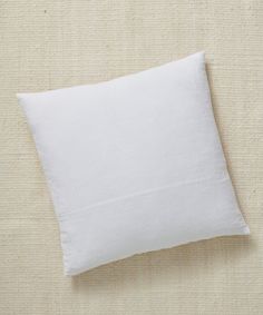 a white pillow sitting on top of a bed