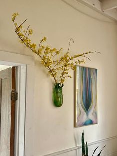 two vases with yellow flowers are hanging on the wall next to a planter