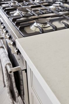 an image of a kitchen setting with stoves and oven hoods in the foreground