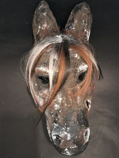 a horse's head is covered in silver and white paint on a black background