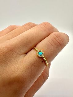 This is a lovely opal Ring with beautiful details. It features a round opal cabochon surrounded by dazzling simulated diamonds to add a little extra bling and beauty. The beaded band goes around the ring completely for an added layer of detail and charm. Choose between a white or blue opal. Either option gives off a beautiful play of color.  ~ 925 Stamped ~ 14K Gold over  ~ Synthetic Opal Center Stone White or Blue ~ High-quality simulated diamonds surrounding ▬ All jewelry pieces are sent in a Opal Rings With Gemstone Accents, Adjustable Gold Opal Ring, Gold Adjustable Opal Ring, Round Shape, Gold Opal Ring Adjustable, Round Opal Jewelry With Halo Detail, Opal Halo Jewelry With Round Shape, Halo Opal Jewelry With Round Shape, Round Opal Ring With Stone Setting, Adjustable Opal Ring Birthstone With Round Stone