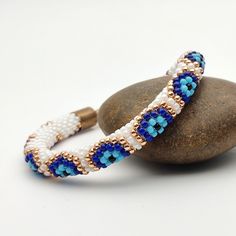 a beaded bracelet sitting on top of a rock