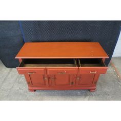 an orange cabinet with two doors and drawers