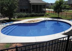 an above ground swimming pool surrounded by a fenced in yard and lawn with chairs